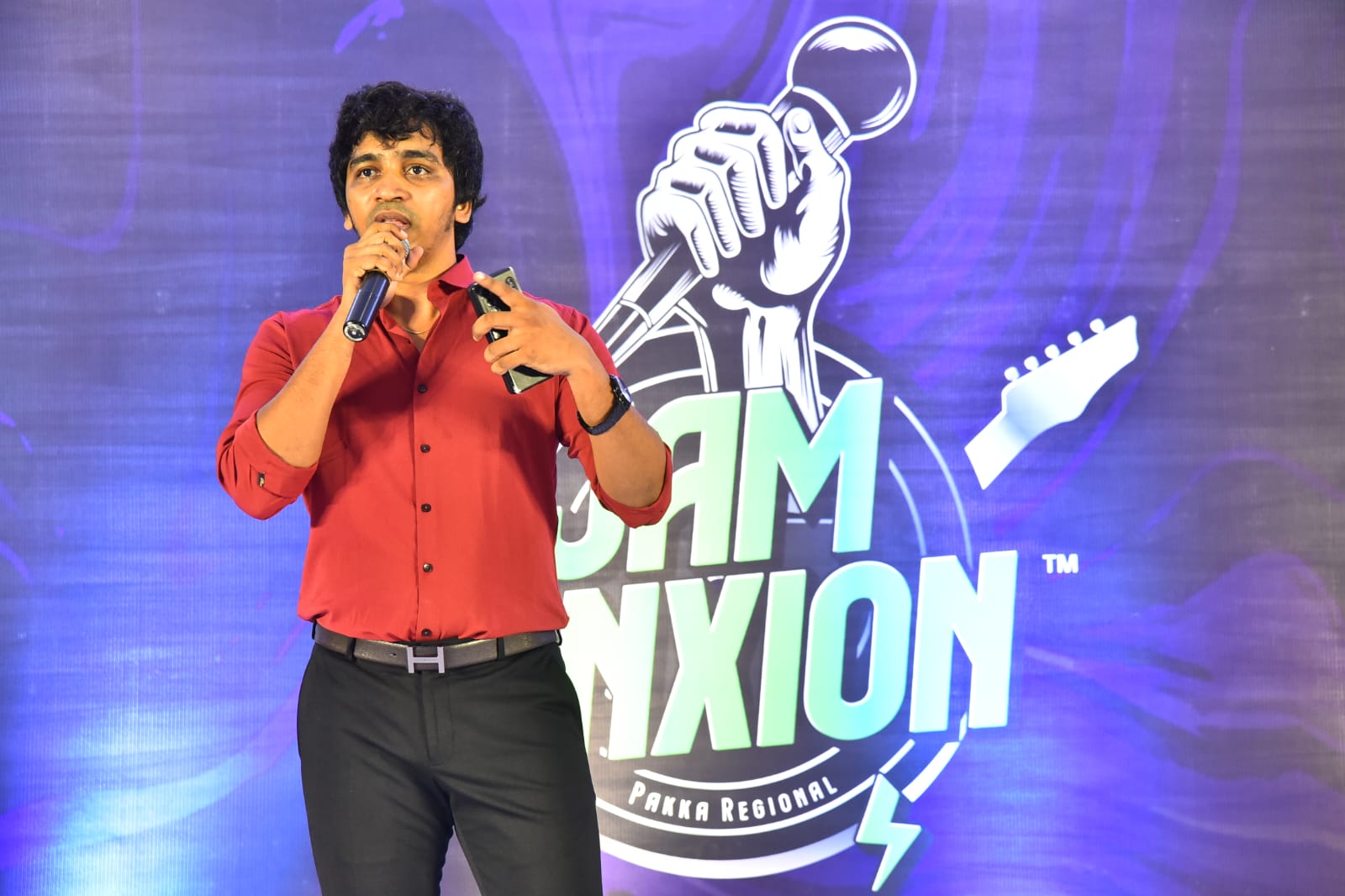 Host on stage with Jam Junxion backdrop